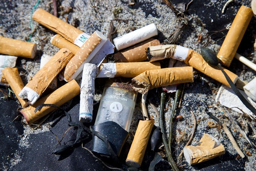 Zigarettenkippen und Plastikmüll am Strand