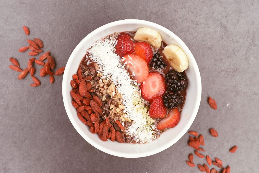 Früchte-Bowl mit getrockneten Goji Beeren, Kokosraspeln und Kakaonibs