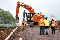 Vorsichtiges Absenken der Leitung ins Erdreich